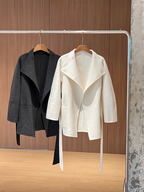 A mid-length woolen coat for women, made entirely of wool and featuring a buttoned collar; a simple yet sophisticated design perfect for autumn and winter.
