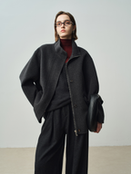 A stylish women’s winter coat with a zipper on both sides, featuring a stand-up collar and a short length; made of wool.