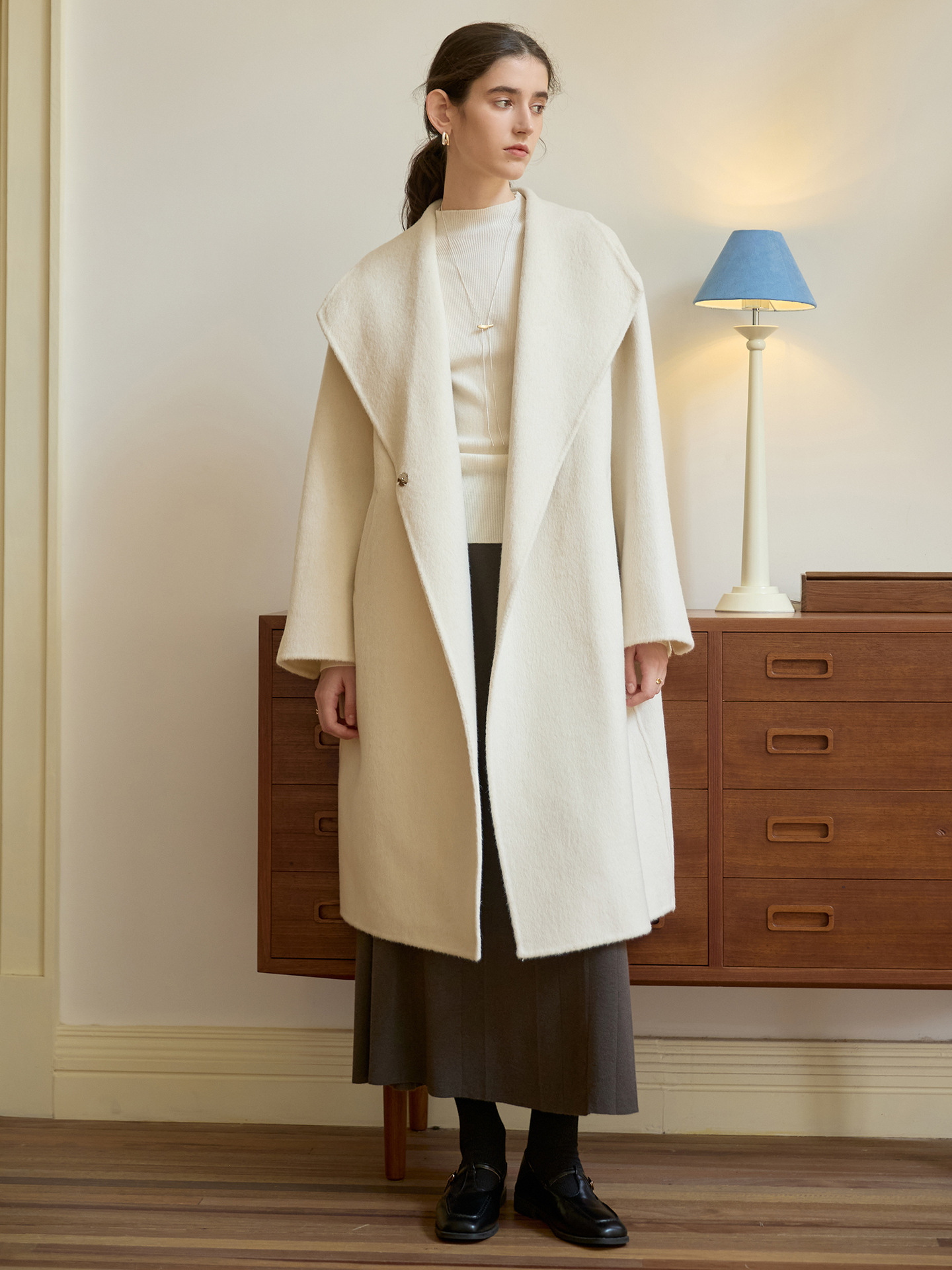 A new autumn/winter women’s coat made of high-quality woolen fabric. This long coat features a solid color, provides excellent warmth, and enhances the wearer’s elegance. It is also equipped with straps for a more stylish look.