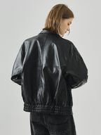 Black leather jacket for women – a stylish, cool, and gender-neutral garment perfect for autumn and winter. Features a loose fit and a stand-up collar, giving it a distinctive biker jacket style.