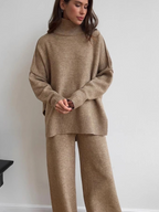 Women’s knitted set consisting of a thick, loose sweater with high collar and wide-leg pants – a two-piece outfit.